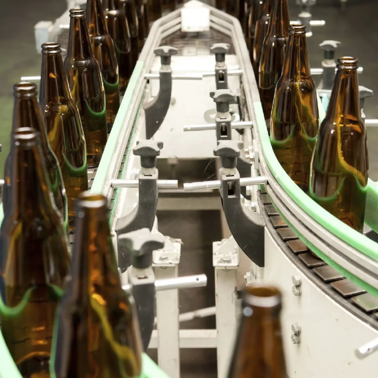 glass bottles being moved along the conveyor belt in the factory